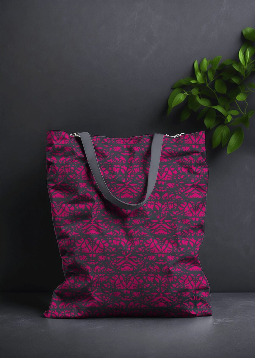 Stoffdesign von Vandyra Design. Tasche mit mystischem Muster. Motiv eines verschlungenen Greenman und Motten. Das Muster ist schwarz-pink. Der Hintergrund ist dunkelgrau und als Deko sieht man eine Pflanze zum Teil abgebildet.