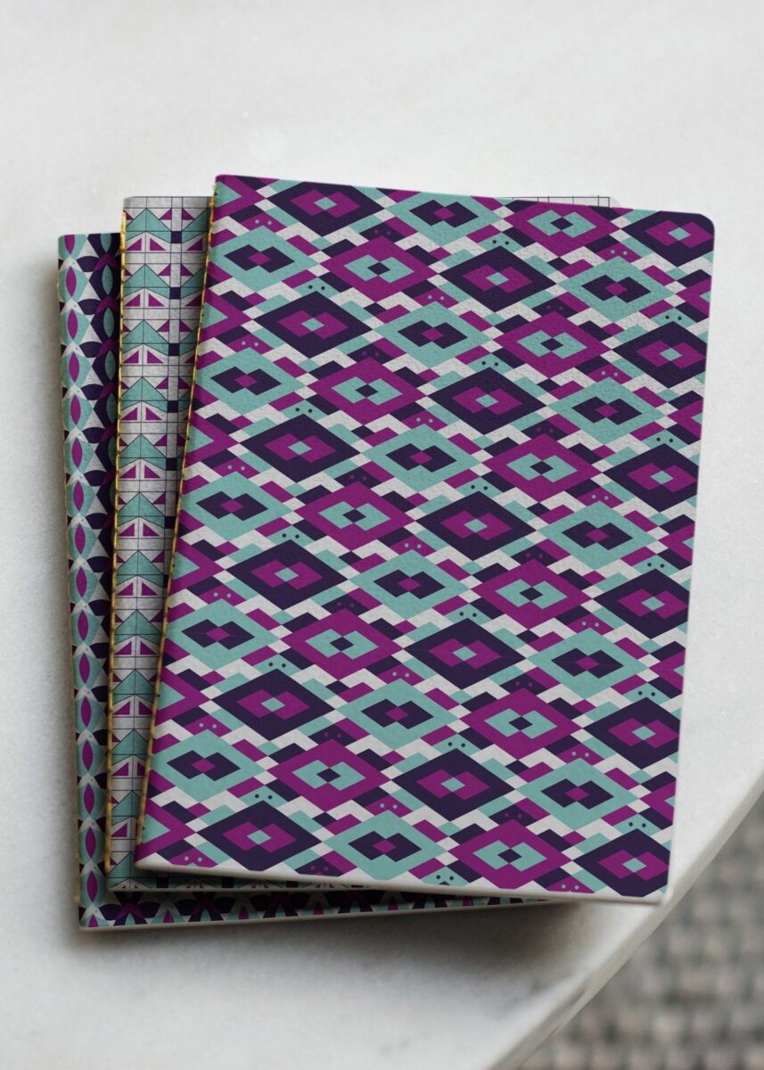 3 seitlich versetzte Notizbücher mit verschiedenen Mustern zu geometrischen Tieren. Schildkröte, Katze und Fisch. In den Farben Mint, Plump, Indigo und Weiß. Das Design ist von Vandyra Design.